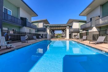 A swimming pool in front of apartment buildings.